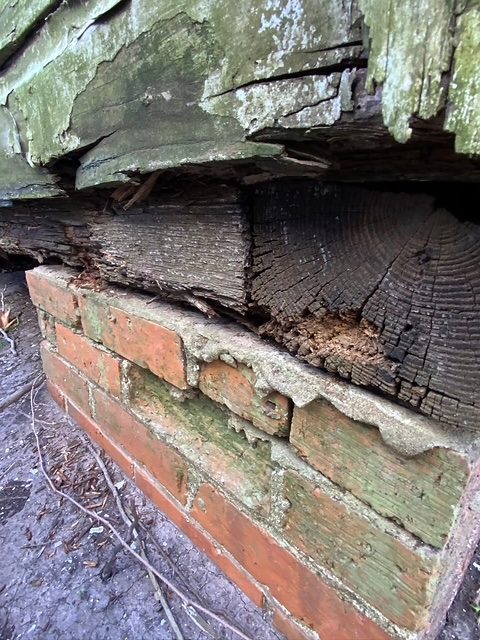 Deteriorated wood framing above a brick veneer wall
