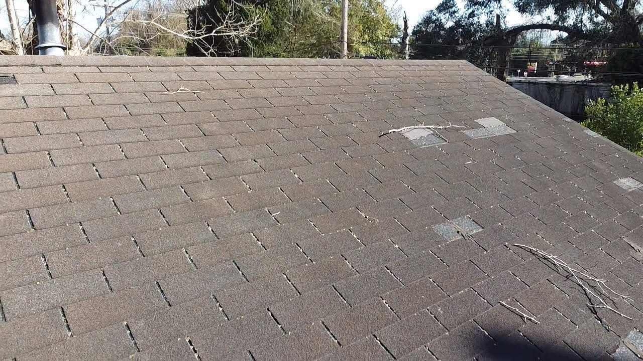 Damaged and displaced shingles documented on a roof slope