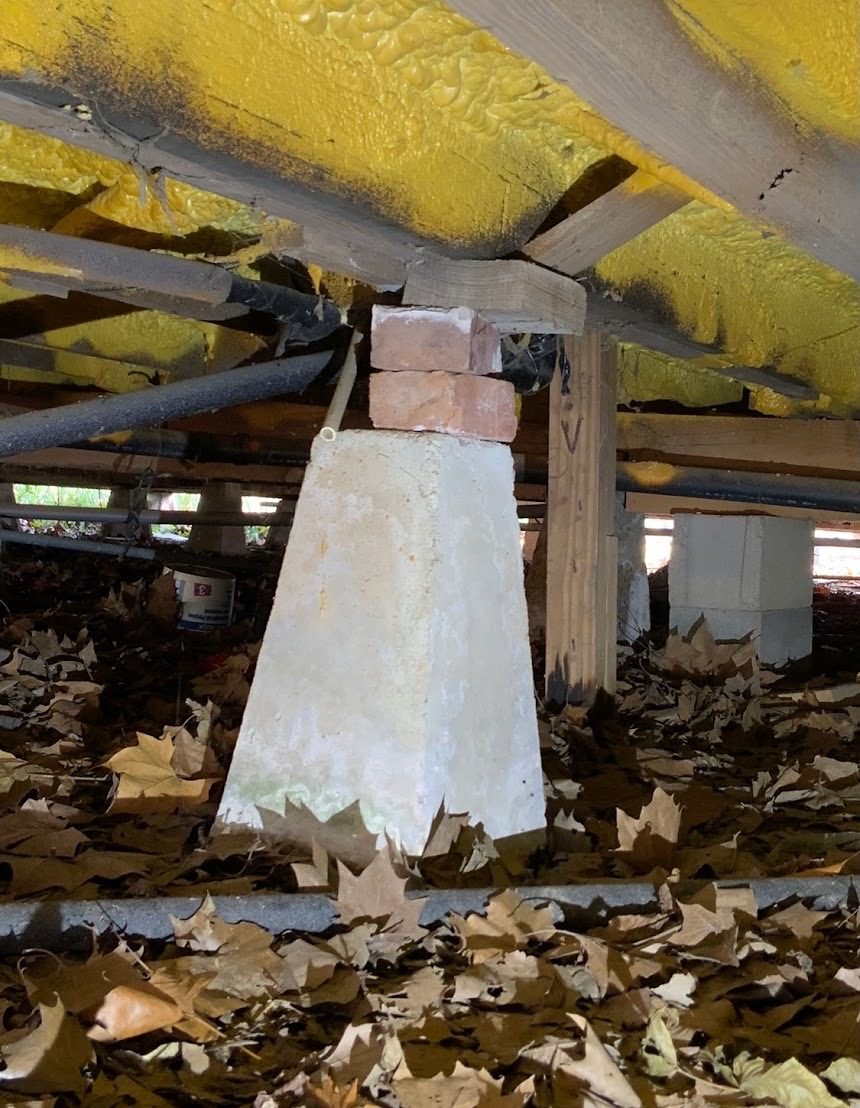 Fallen underfloor insulation around a crawlspace pier