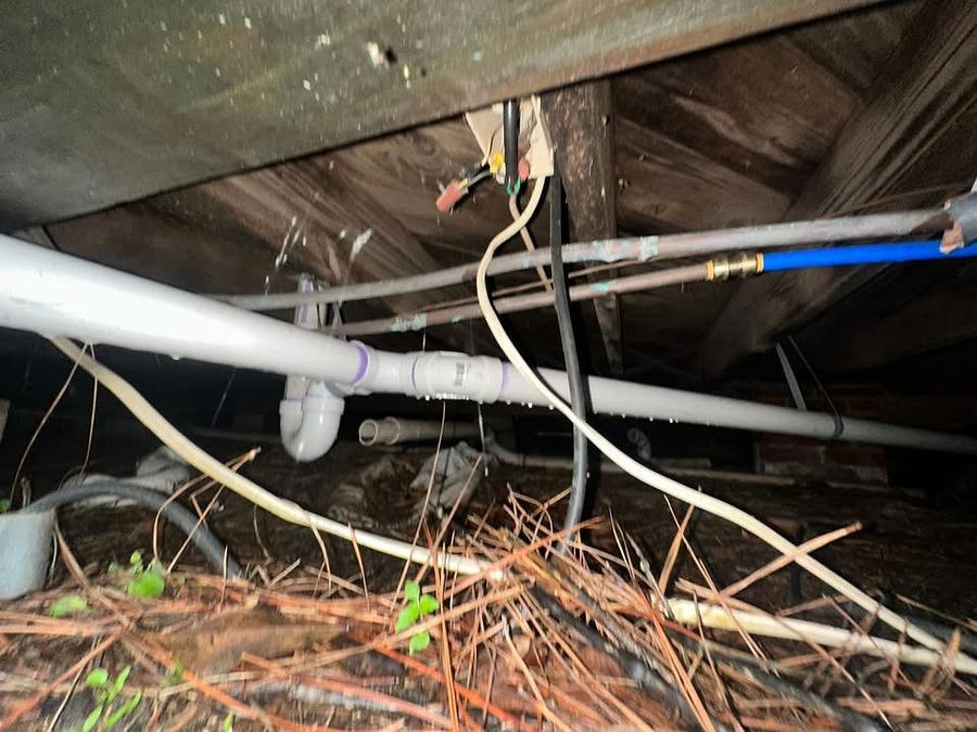 Supply lines and wiring routed low through a crawlspace