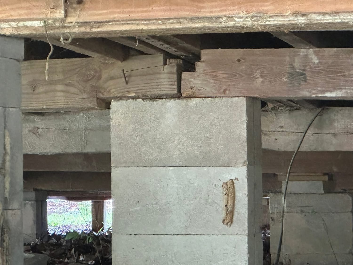 Concrete block pier and girder bearing under a raised floor