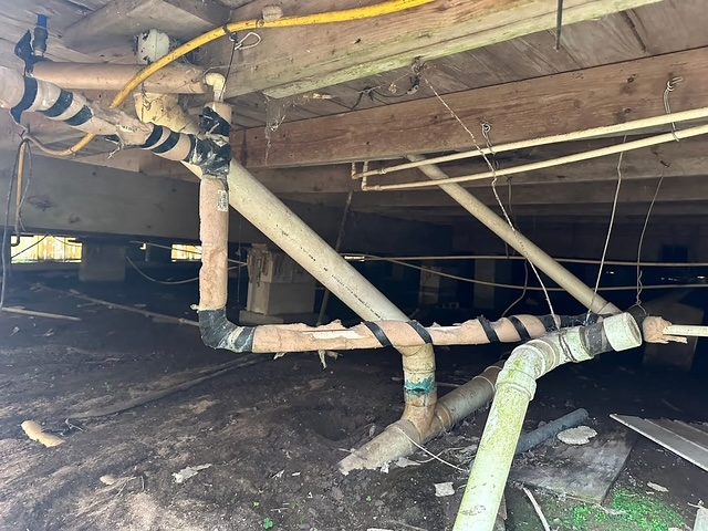 Drain and supply piping beneath a raised home